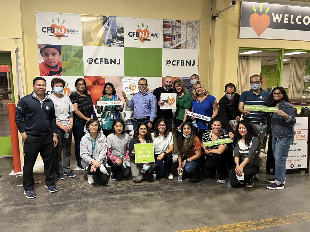 Group of people posing for a photo holding signs that read i am fighting hunger