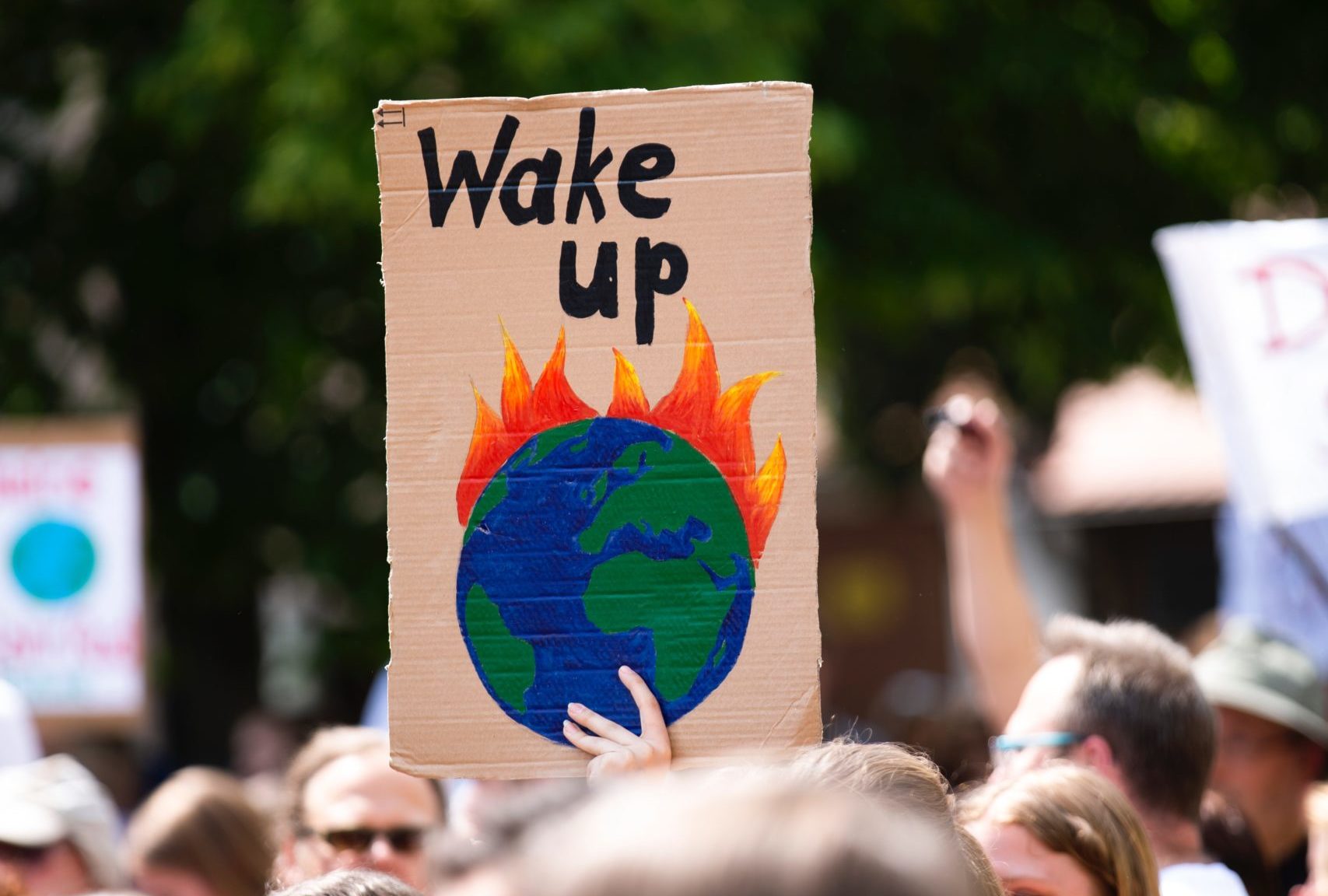 Protester Holding Photo of Burning Earth "Wake Up"